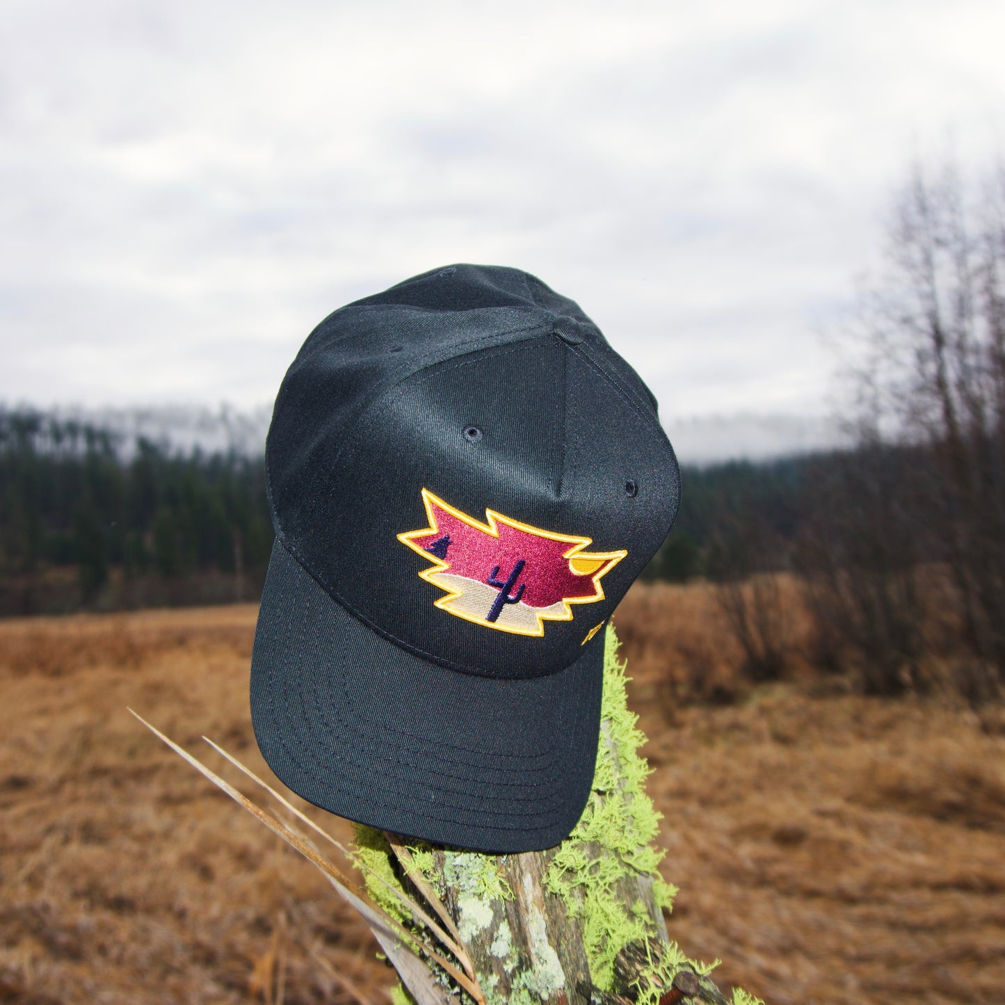 a black hat with a red maple leaf on it
