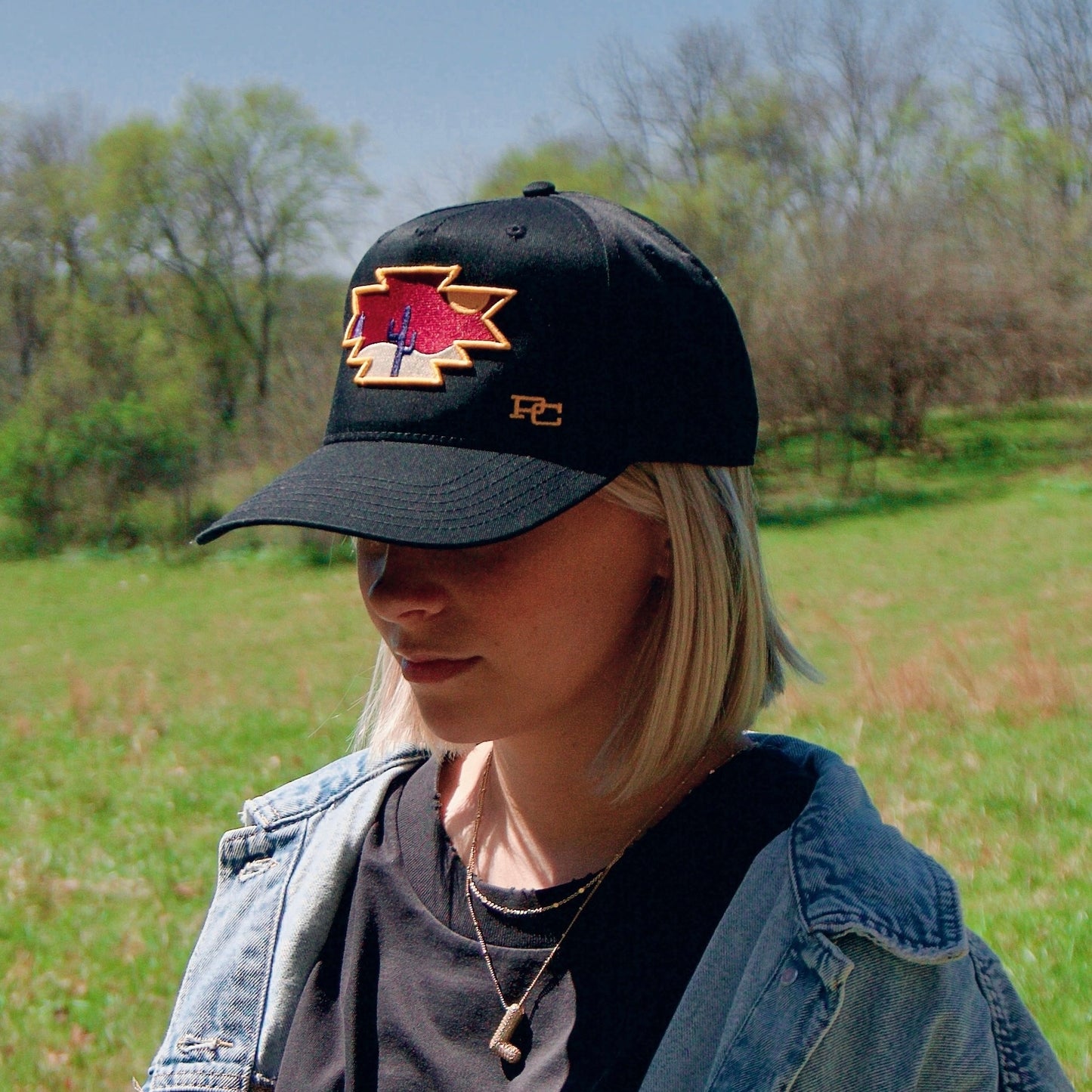 a woman in a denim jacket and a black hat